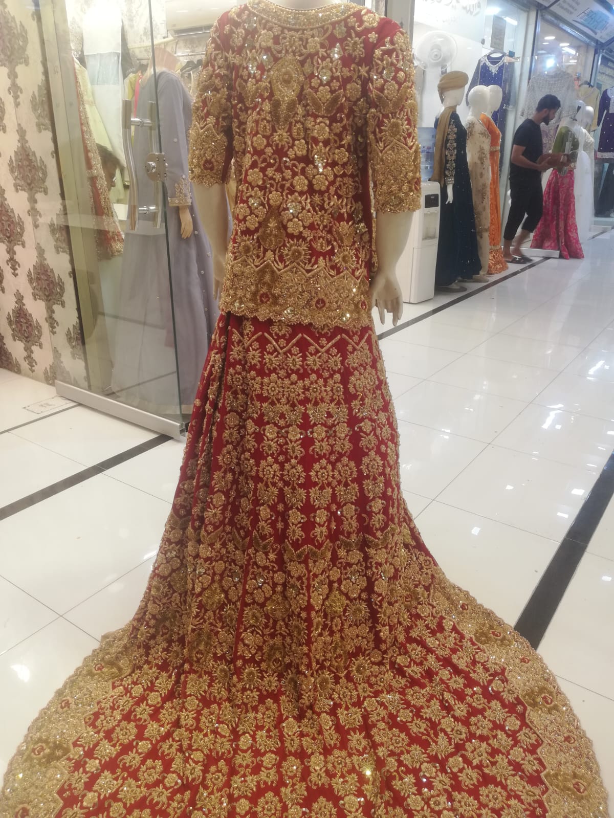 A red and gold bridal lehenga with full zardozi embroidery and a back tail, from the Chand Bridals atelier